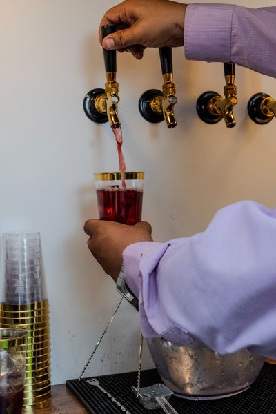 Un bartender sirve un cóctel desde una llave dispensadora dorada